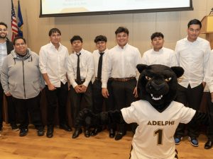 Adelphi students posing alongside  the Adelphi Panther 