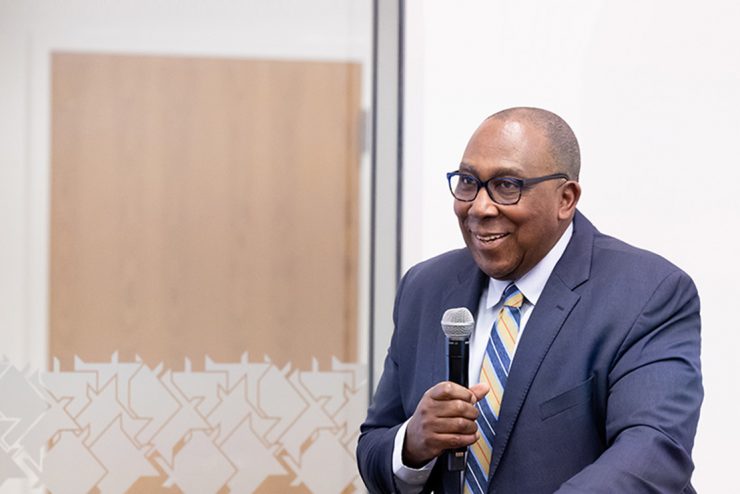 Dr. Bakari speaking at a podium at Adelphi University