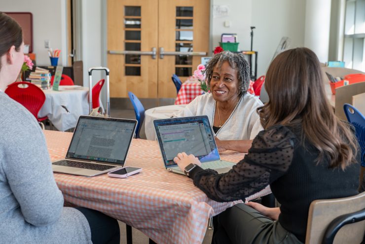 Fayth Vaughn-Shavuo, PhD, working directly with two graduate students at Adelphi.