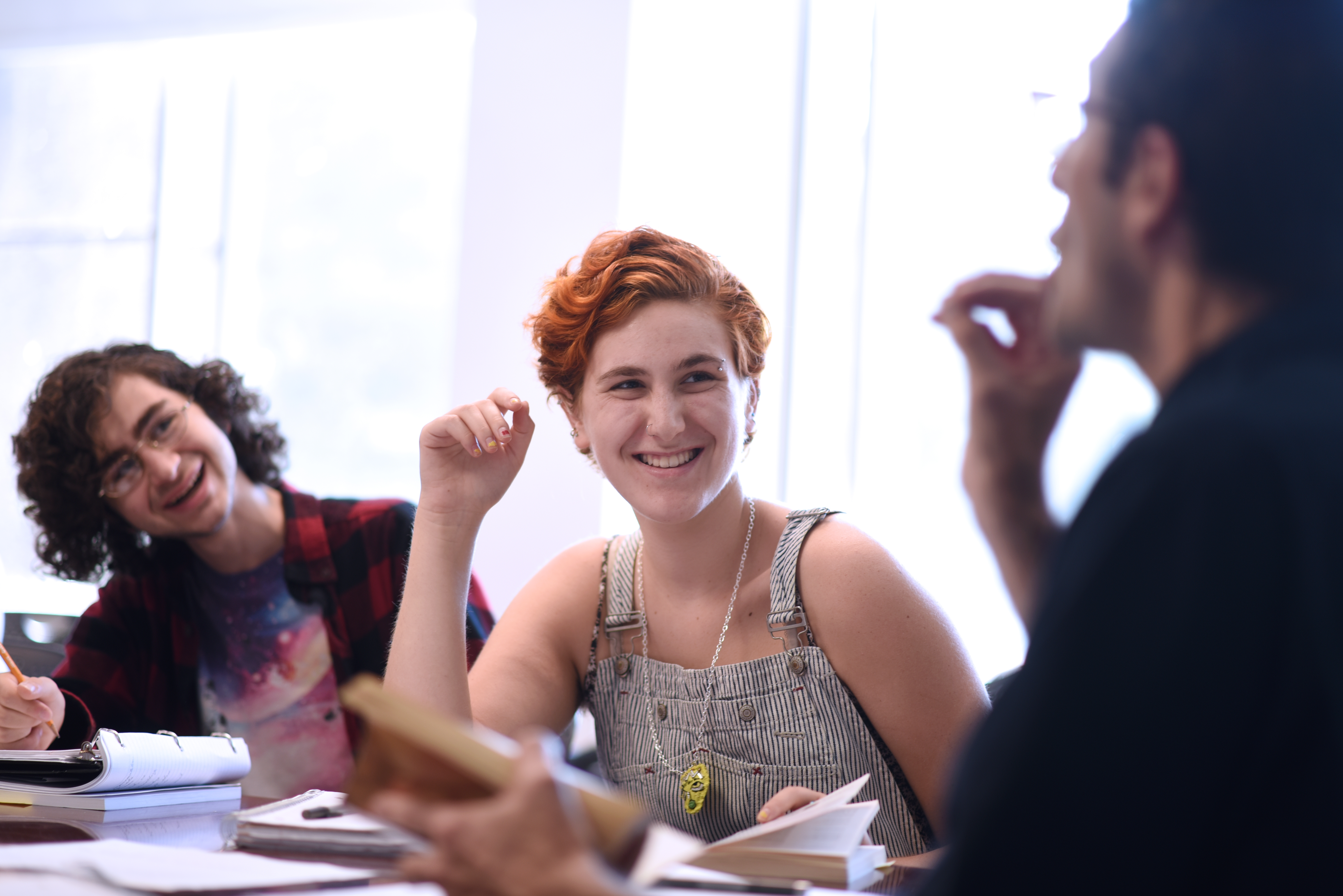 Three students talking at a table