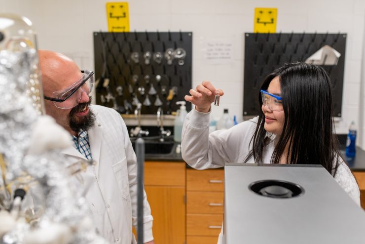 Adelphi Science Professor Silverio with a biology student holding a sample in the lab.