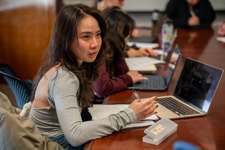 Students taking notes in class on a laptop