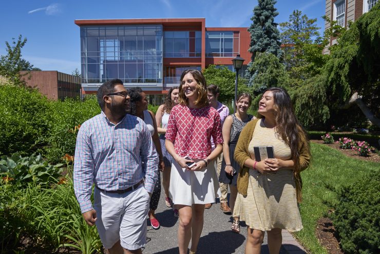 Three professionals walking on Adelphi University's campus.