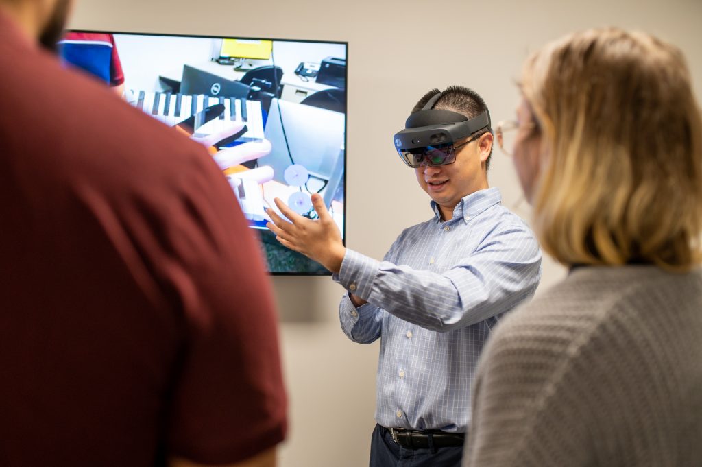 An Adelphi University professor wears VR headset in the Human Interaction Lab.