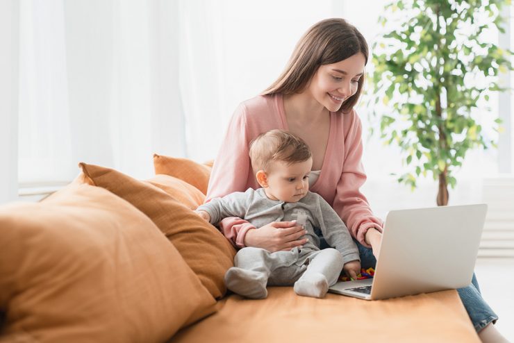 Mother studying with child in her lap.