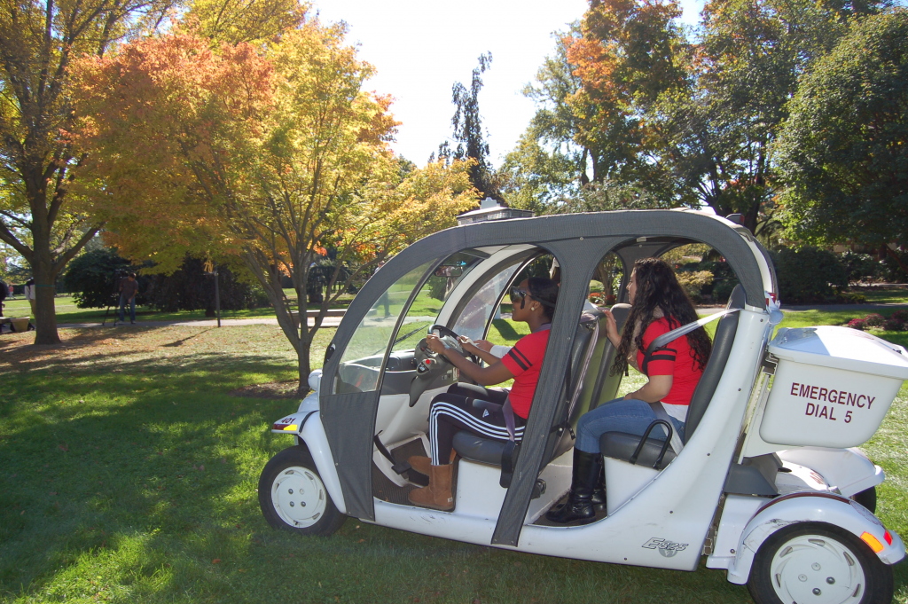 Adelphi students drive a Public Safety gold cart with "drunk goggles" to simulate drunk driving.