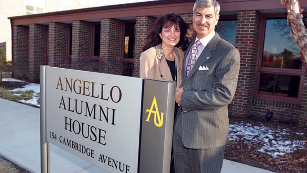 Phyllis and Frank '77 standing in front of the new sign for the Angello Alumni House