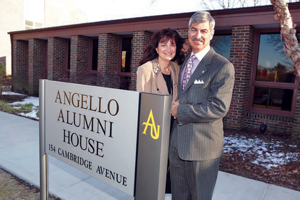 Phyllis and Frank '77 standing in front of the new sign for the Angello Alumni House