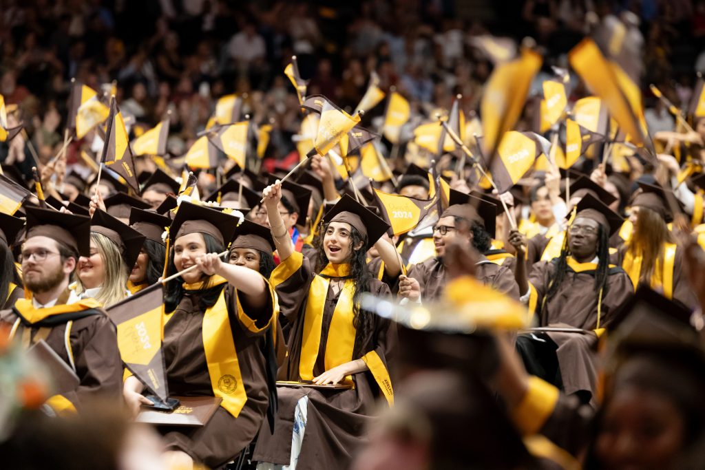 A large group of graduates waving Adelphi pennants at the 2024 Commencement ceremony.