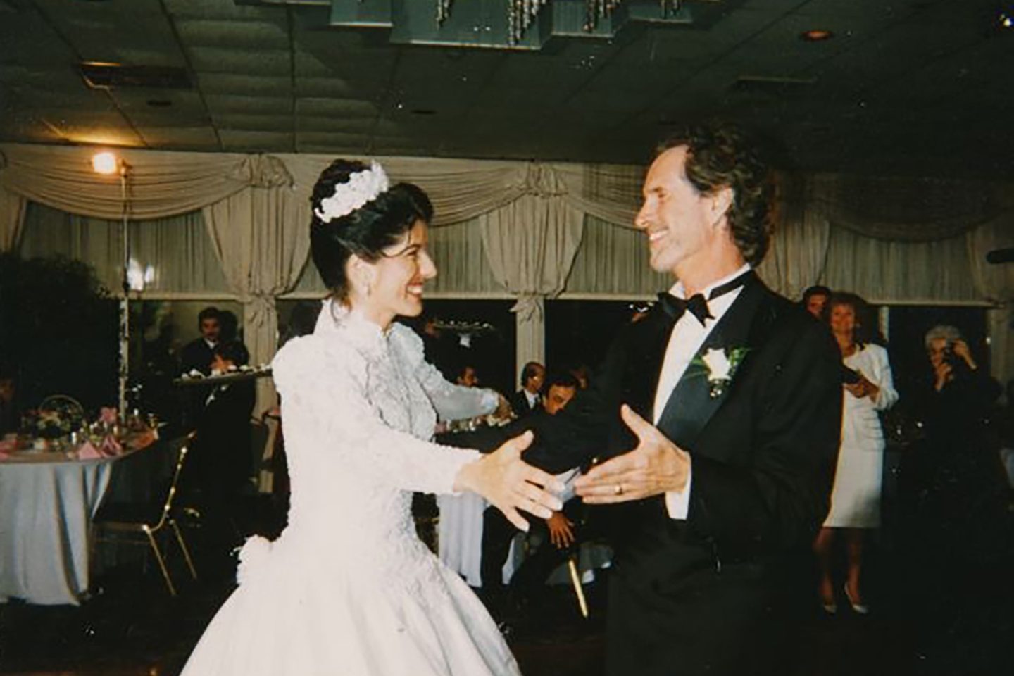 Wedding photo of man and woman dancing, smiling and facing each other