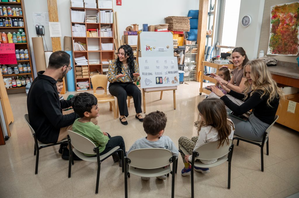 A student teacher observes a young child seated in a circle at Adelphi's Early Learning Center. 