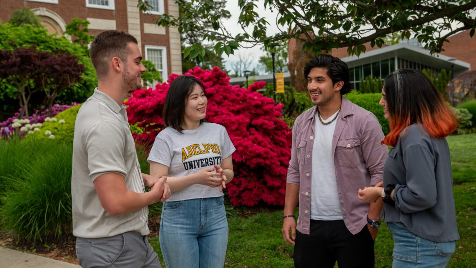 Students of different ethnicities outdoors on campus grounds.