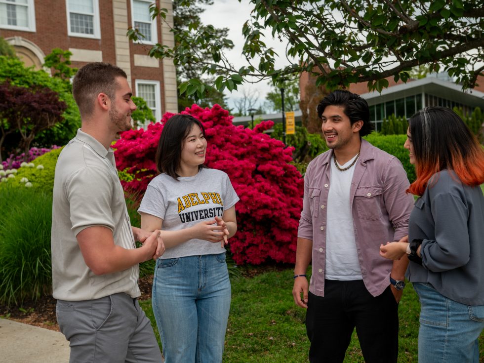 Students of different ethnicities outdoors on campus grounds.