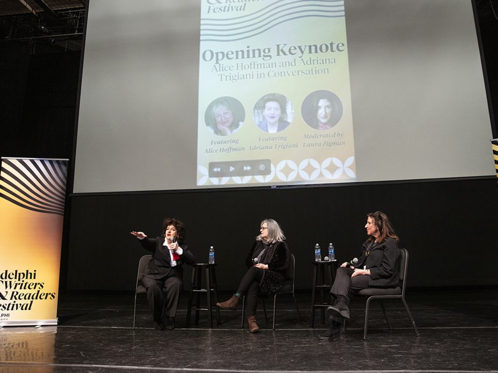 Three women seated on a stage. To the right, banner reads "Adelphi Writers and Readers Festival." Screen overhead reads: "Opening keynote."