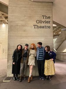 Students standing in front of a wall labeled "The Olivier Theatre."