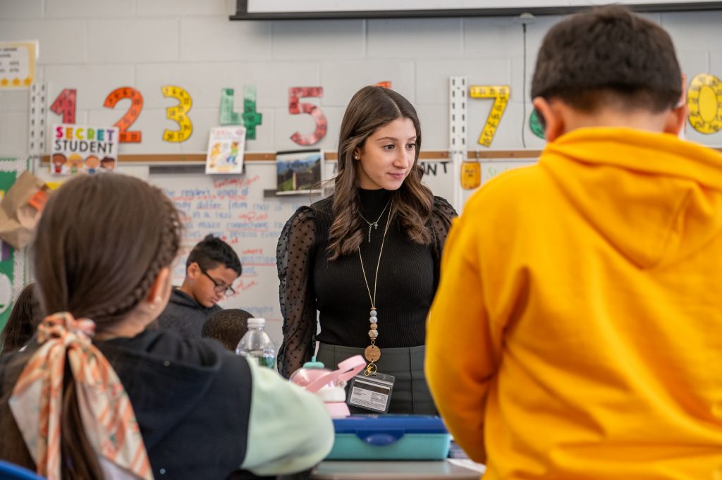 Adelphi University student teacher in the classroom with elementary-aged children.