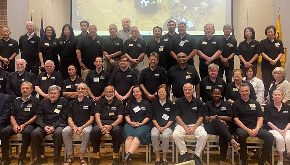 A gathering of nearly 50 faculty and staff members, mostly wearing black Adelphi University shirts