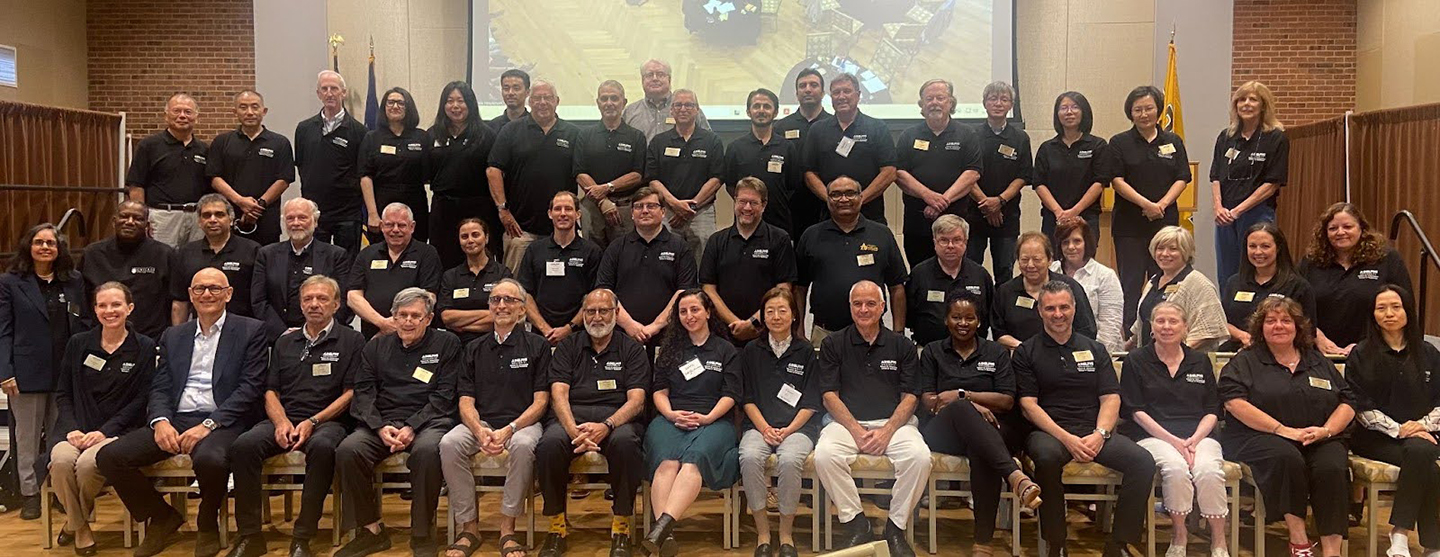 A gathering of nearly 50 faculty and staff members, mostly wearing black Adelphi University shirts