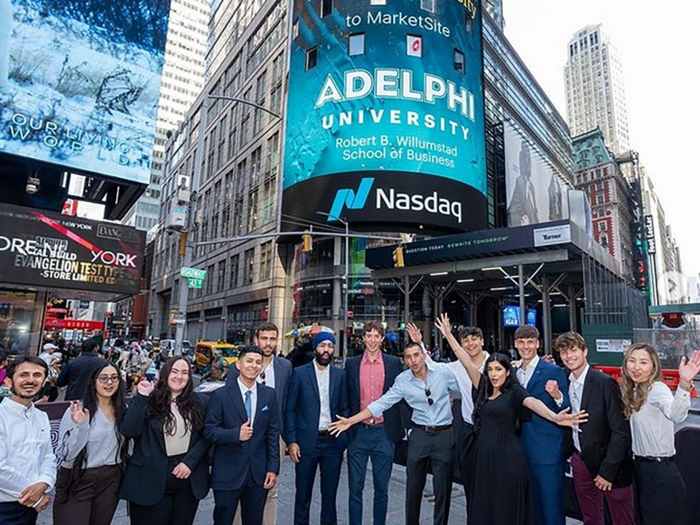 Thirteen students stand in front of the Nasdaq stock exchange building in Manhattan.