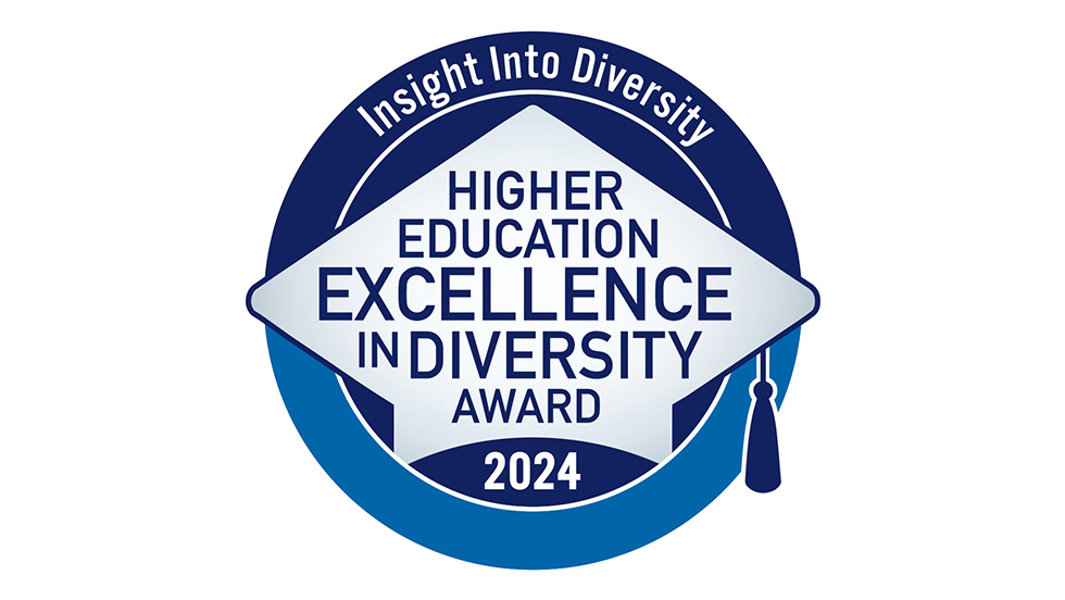 A blue and white badge displaying the Higher Education Excellence in Diversity (HEED) Award in the shape of a graduation cap. The badge reads "Insight Into Diversity - Higher Education Excellence in Diversity Award 2024"