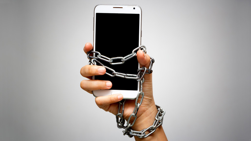 Image of a smartphone chained to someone's hand.