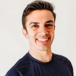  A smiling white man with short black hair in a dark blue shirt