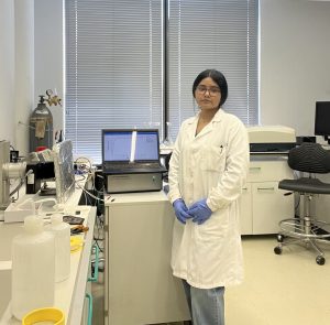 A woman in a science lab, wearing a lab coat.