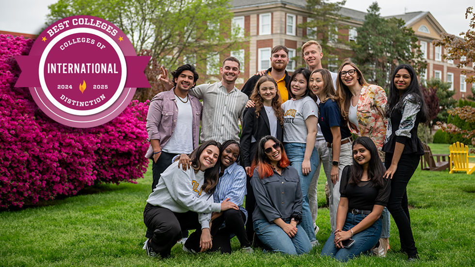 A group of smiling students outside on the lawn, with a purple badge reading: “Best Colleges - Colleges of Distinction - International, 2024–2025”