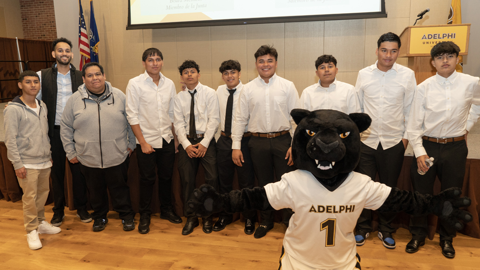 Adelphi students posing alongside  the Adelphi Panther 