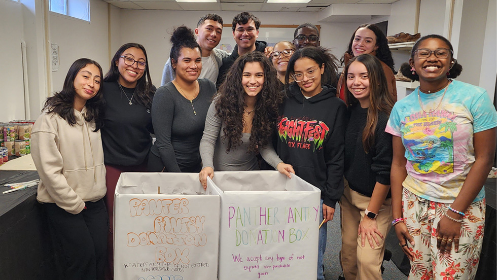 A group of students gather around food collection boxes.