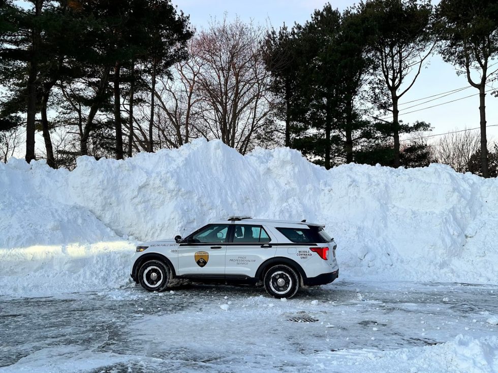 Public Safety vehicle in front of large pile of snow.