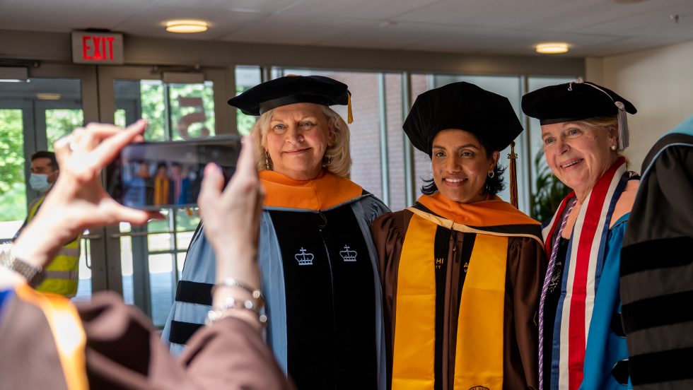 Three doctoral nursing students in regalia.