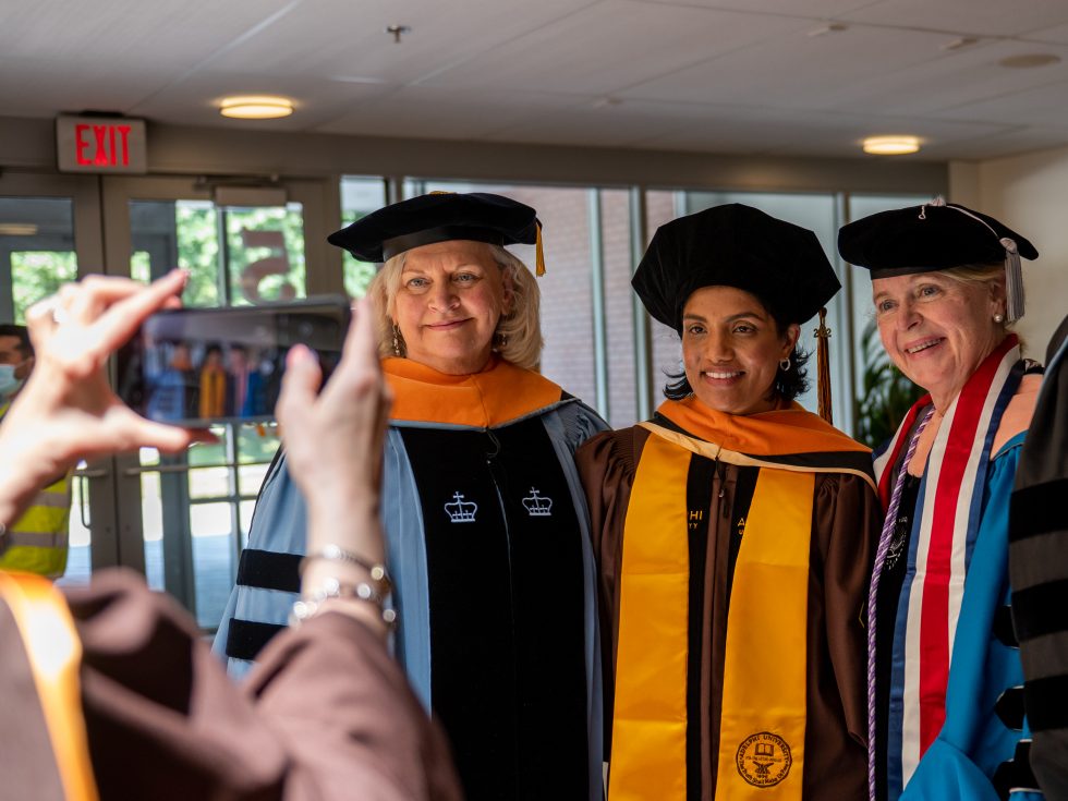 Three doctoral nursing students in regalia.