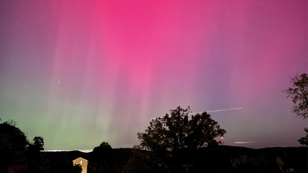 An array of pink aurora lighting up a night sky