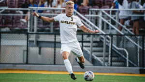 Carhed in action for the Adelphi soccer team, preparing to kick the ball.