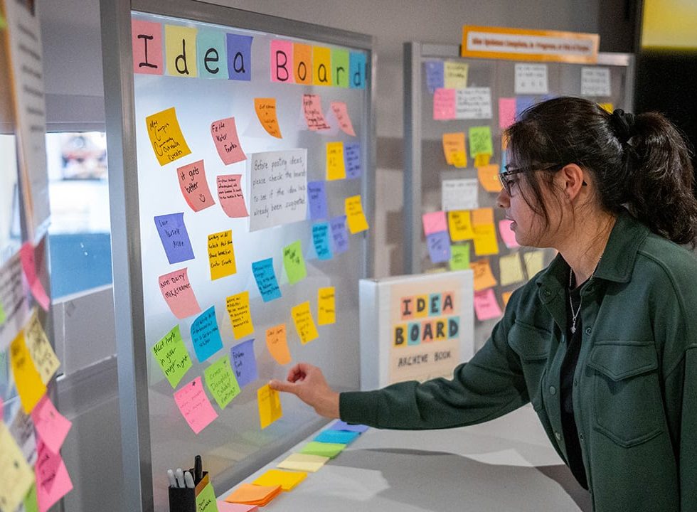 Women putting post its on an idea board